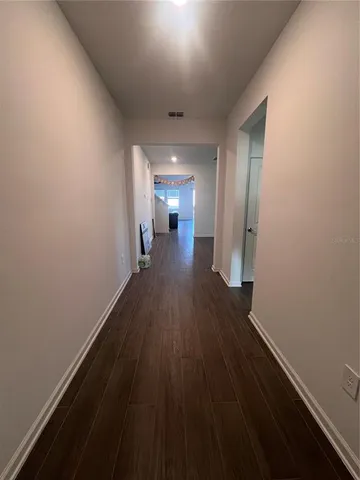 a view of a hallway with wooden floor