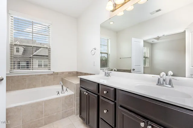 a bathroom with a tub sink and mirror