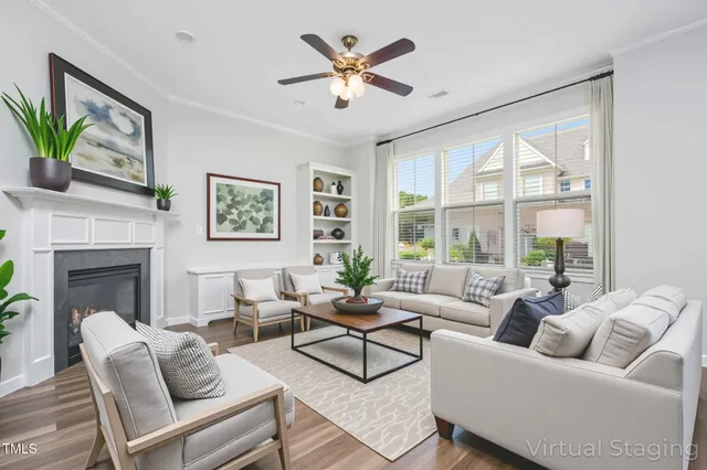 a living room with furniture a fireplace and a large window
