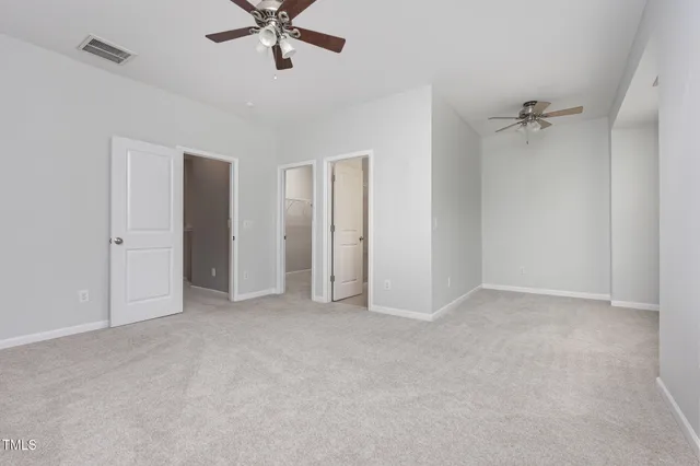 an empty room with closet and fan