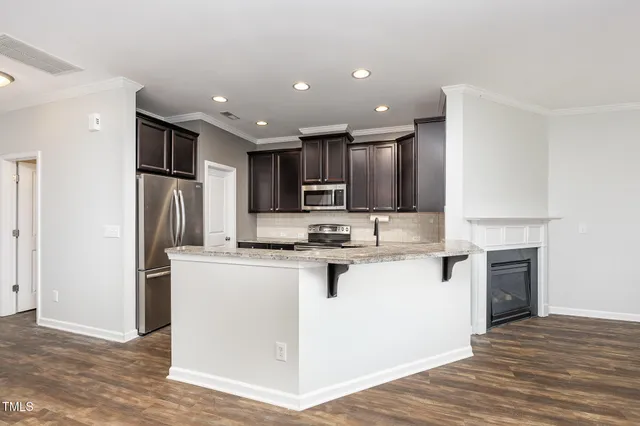 a kitchen with kitchen island a sink stainless steel appliances and cabinets