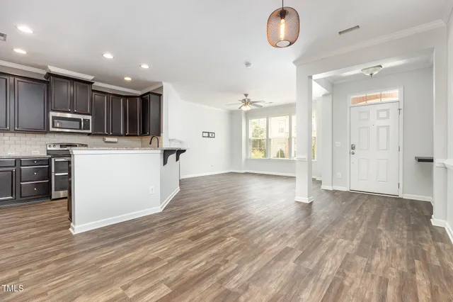 a view of kitchen with microwave a refrigerator and a stove