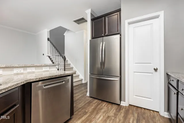 a kitchen with stainless steel appliances granite countertop a refrigerator and a sink
