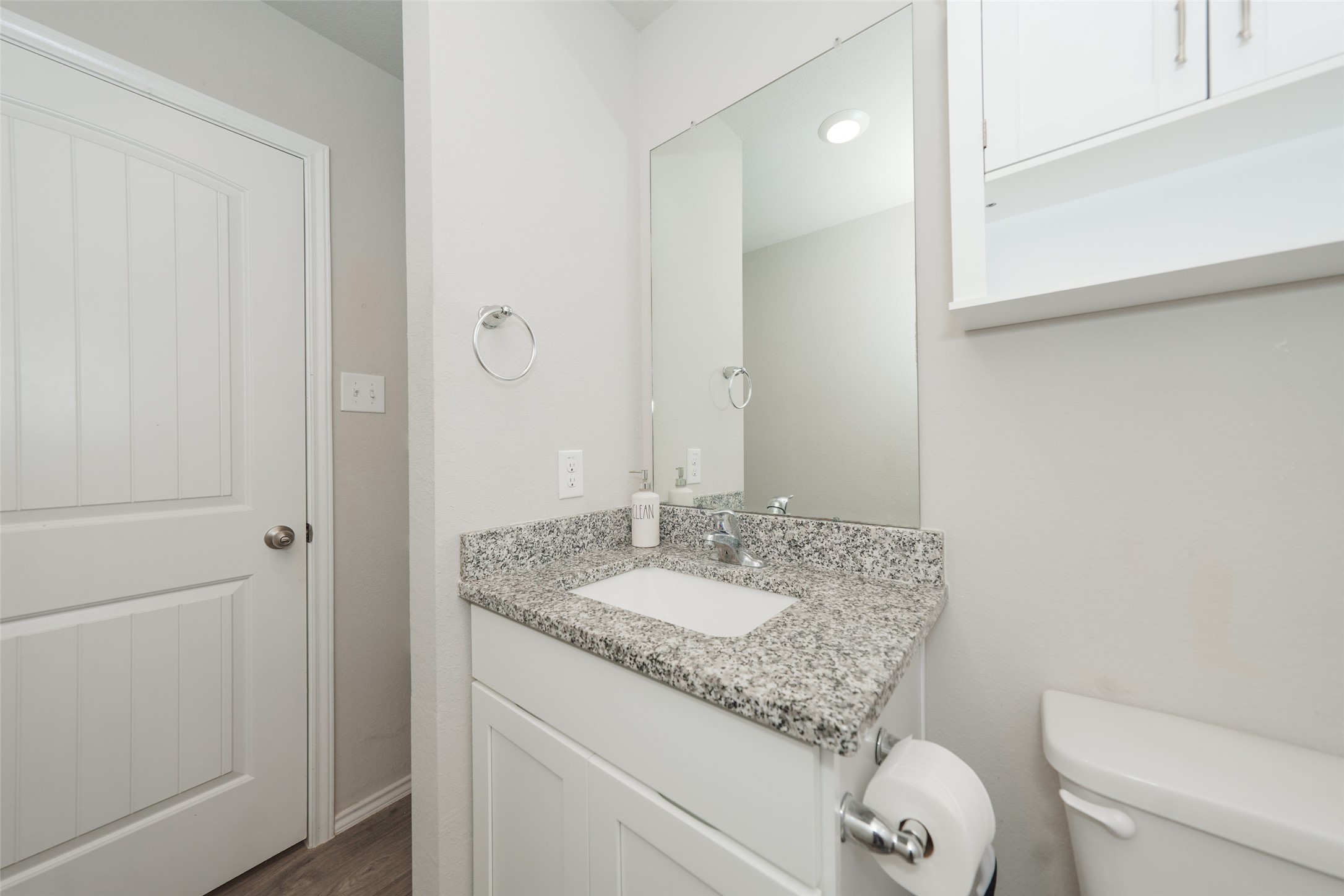 2407 Divot Lane Navasota, TX 77868 - Photo 4 of 37 a bathroom with a granite countertop sink a toilet and a mirror
