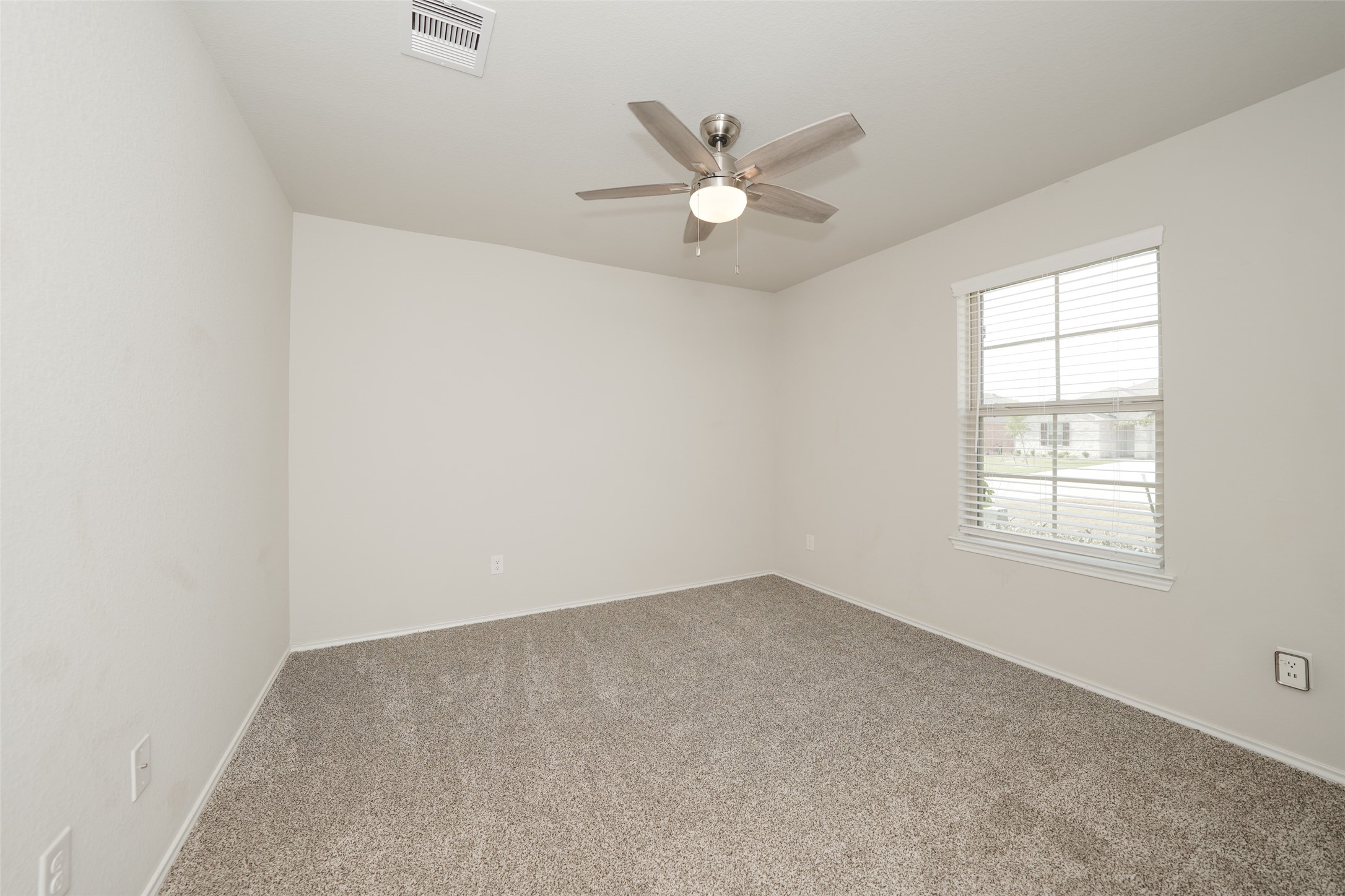 2407 Divot Lane Navasota, TX 77868 - Photo 6 of 37 an empty room with a window and a fan