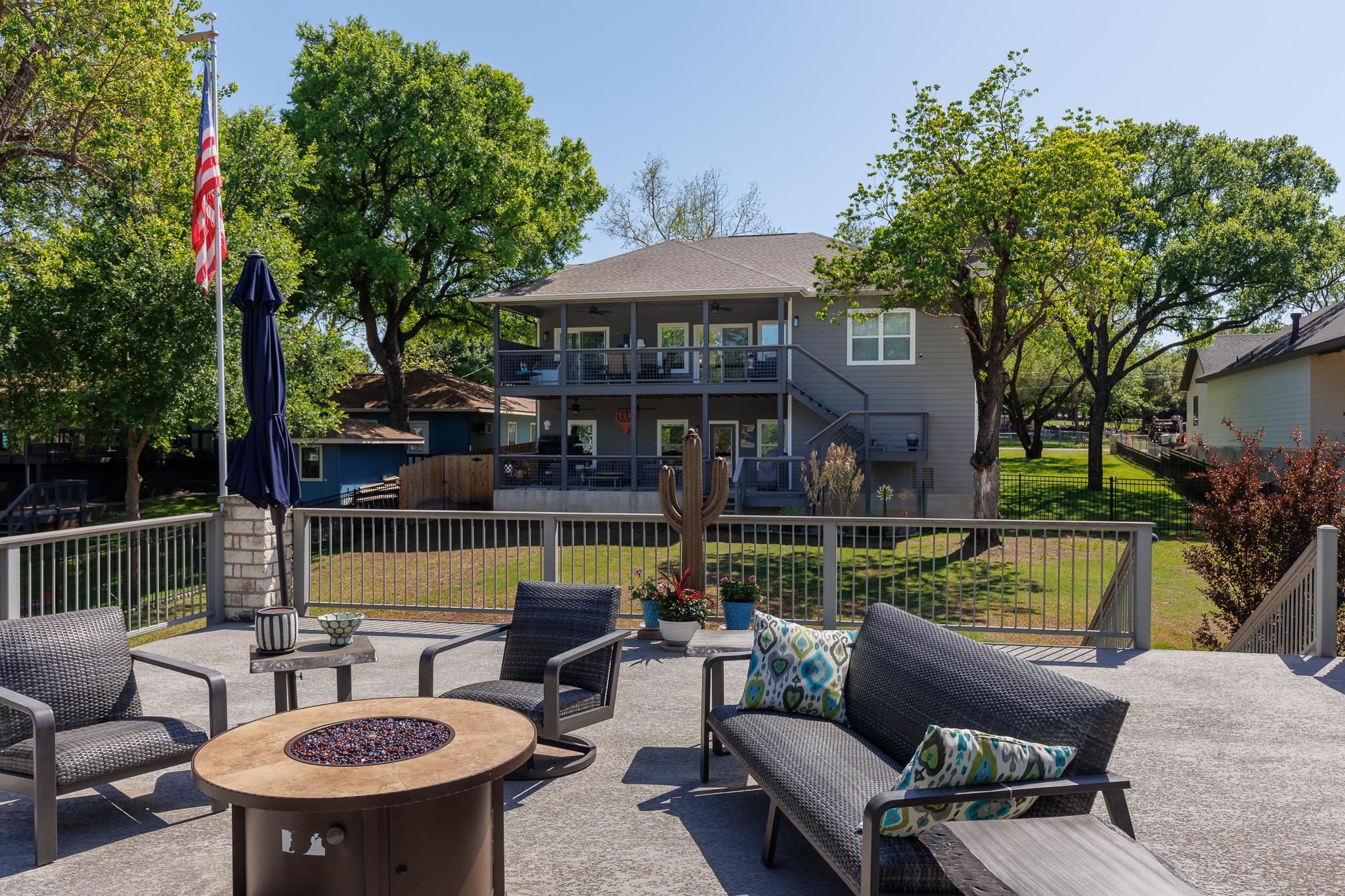 1633 Aztec Kingsland, TX 78639 - Photo 27 of 30 a view of a patio with couches table and chairs under an umbrella with a small yard