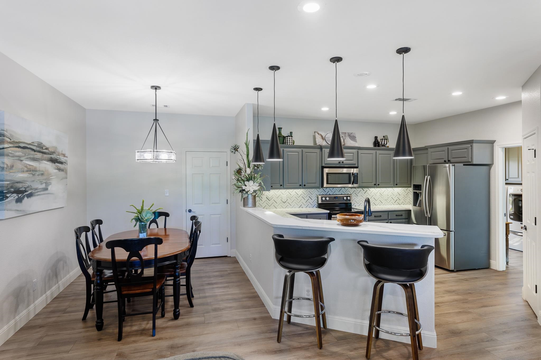 1633 Aztec Kingsland, TX 78639 - Photo 6 of 30 a kitchen with stainless steel appliances kitchen island granite countertop a dining table chairs and a refrigerator