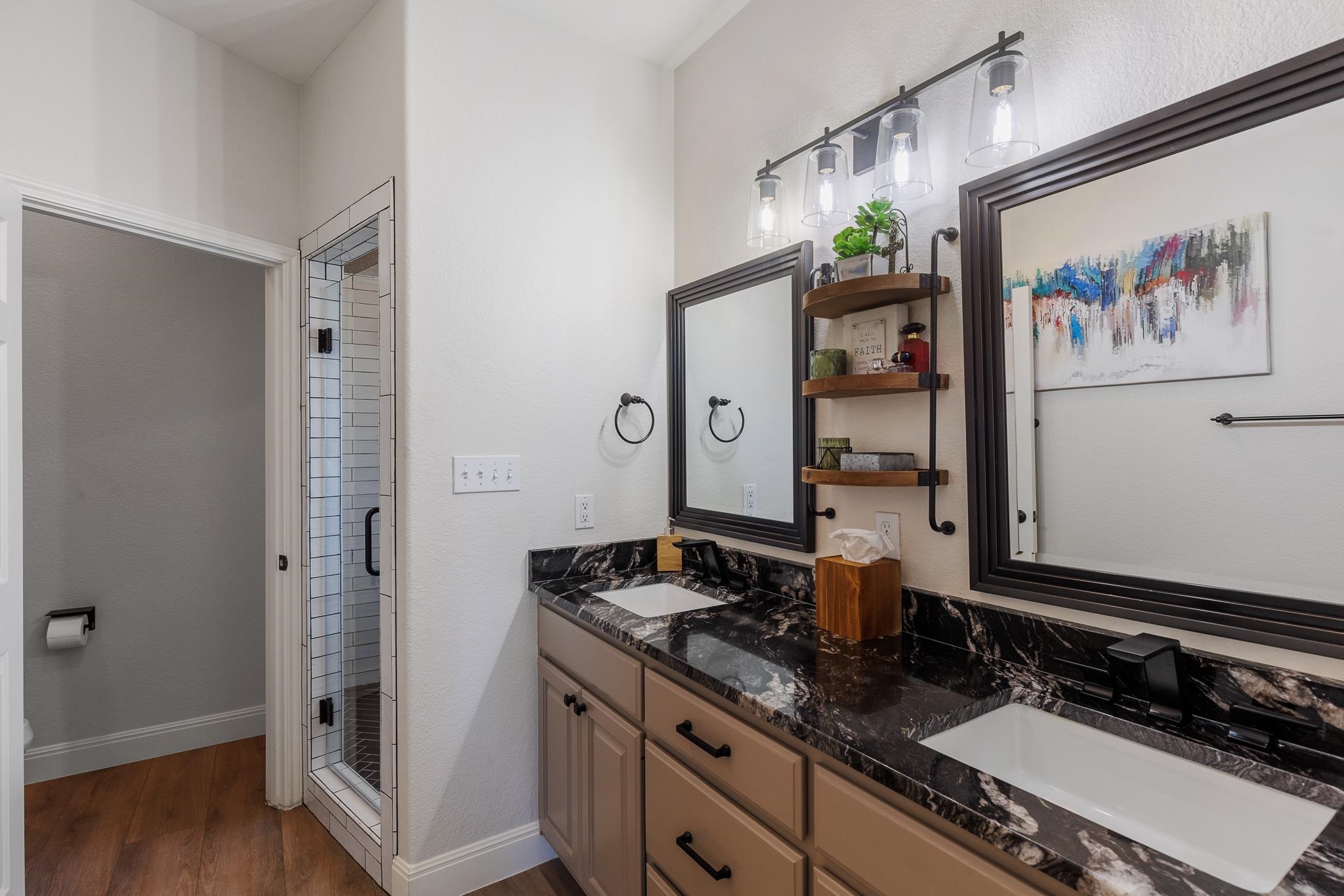 1633 Aztec Kingsland, TX 78639 - Photo 10 of 30 a bathroom with a granite countertop sink a mirror and a shower