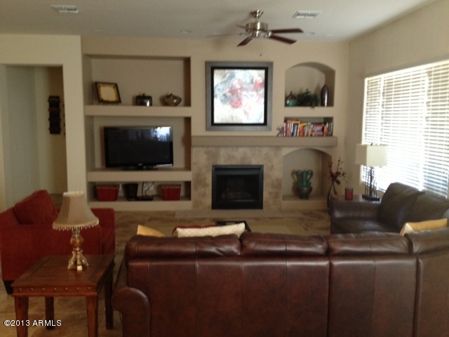 17902 West Verdin Road Goodyear, AZ 85338 - Photo 6 of 10 a living room with furniture a flat screen tv and a fireplace