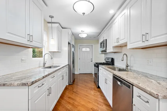 a large kitchen with stainless steel appliances granite countertop a sink stove and cabinets