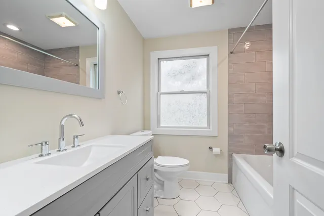 a bathroom with a double vanity sink toilet and shower