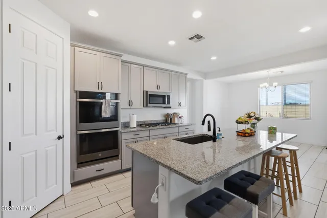 a kitchen with granite countertop a stove refrigerator and microwave