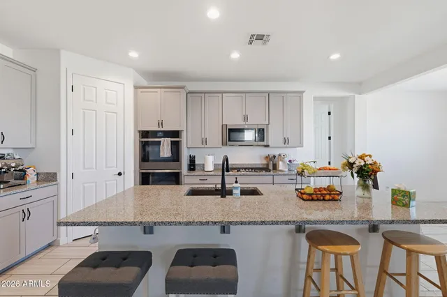 a kitchen with granite countertop a sink and white cabinets