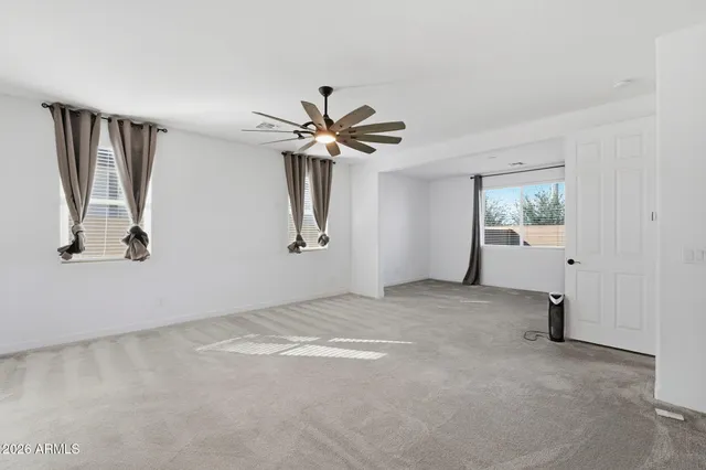 a view of a livingroom with a ceiling fan and window