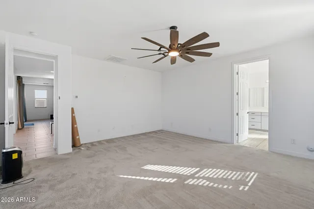 an empty room with closet and a ceiling fan