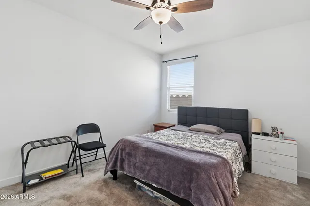 a bedroom with a bed and a ceiling fan