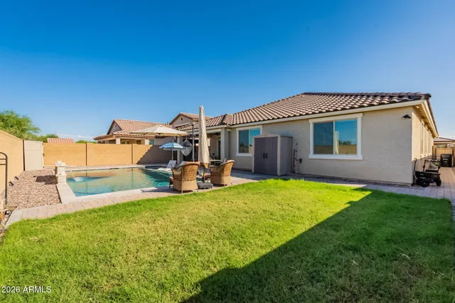 a view of a house with a patio and a yard