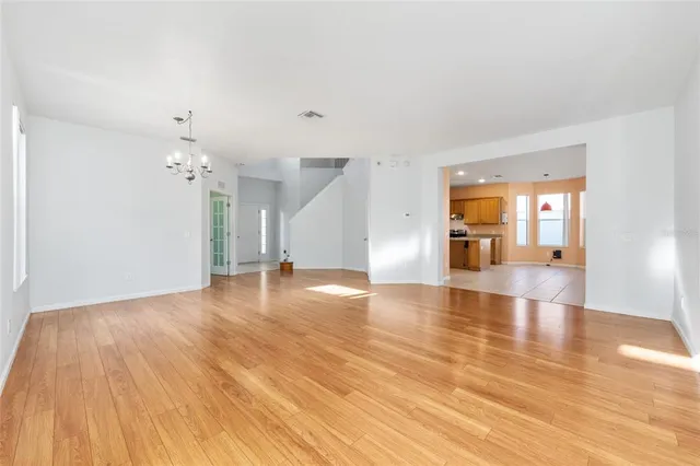 a view of an empty room with window and wooden floor