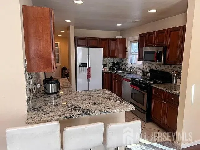 a kitchen with stainless steel appliances granite countertop a sink stove and cabinets