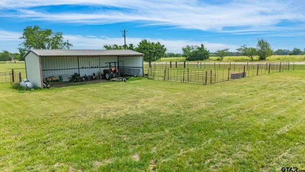 a view of a house with a yard and a large tree