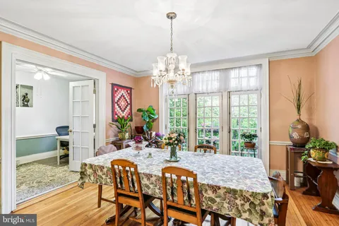 a kitchen with stainless steel appliances granite countertop a stove top oven a dining table and chairs with wooden floor