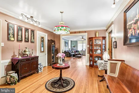 a living room with furniture a chandelier and a flat screen tv