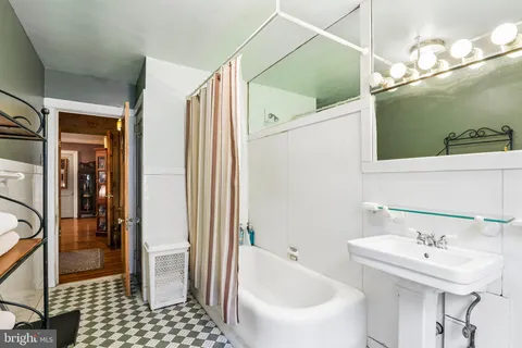 a en suite bathroom with a tub shower and a sink