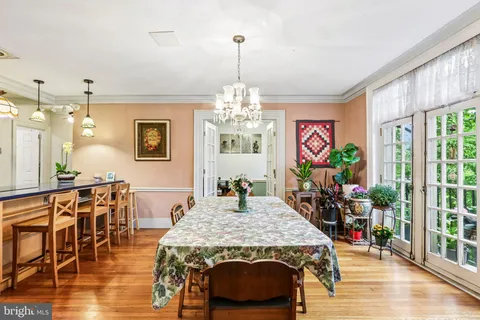 a dining room with furniture a chandelier and wooden floor