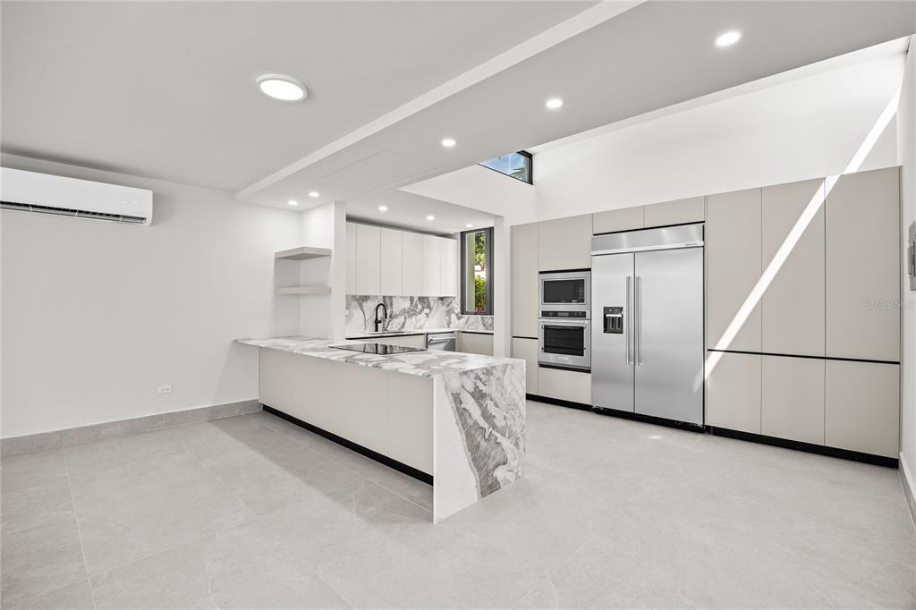 373 Guaynabo Prairie Guaynabo, PR 00969 - Photo 5 of 17 a large white kitchen with white cabinets and stainless steel appliances