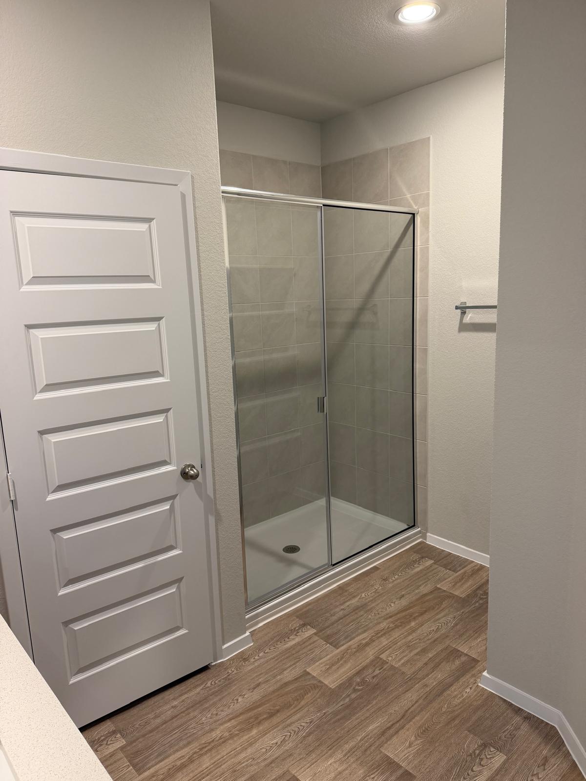 2701 Towy Road Manor, TX 78653 - Photo 24 of 35 A well-appointed shower stall with sliding glass doors and stylish plank flooring provides a refreshing retreat.
