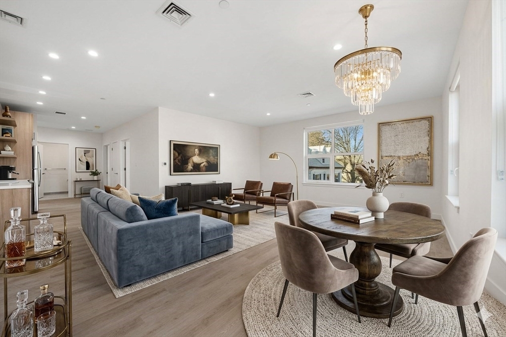 1151 Walnut Street, Unit 301 Newton, MA 02461 - Photo 3 of 14 a living room with furniture a chandelier and a flat screen tv