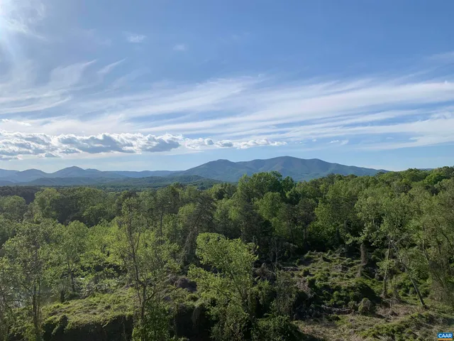 a view of mountain with sunset in background