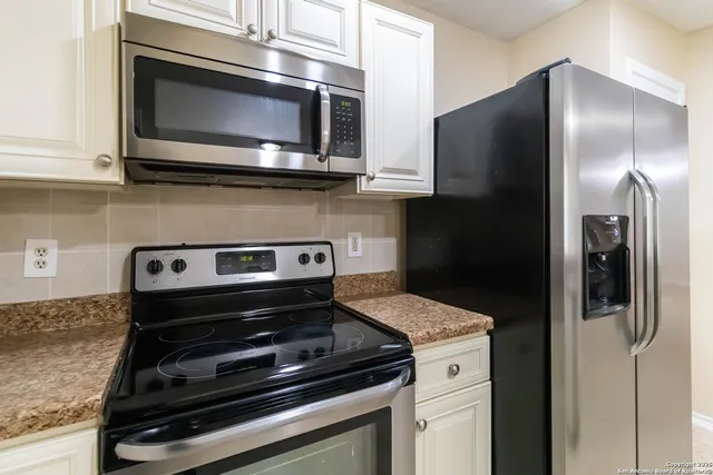 a kitchen with granite countertop cabinets and steel stainless steel appliances