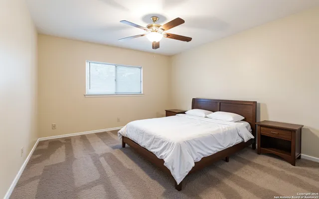 a bedroom with a bed and a ceiling fan