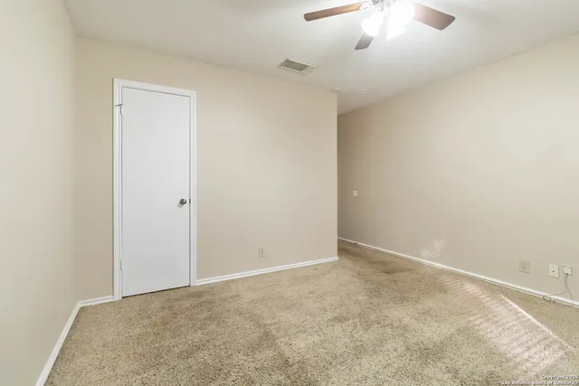 an empty room with a chandelier fan