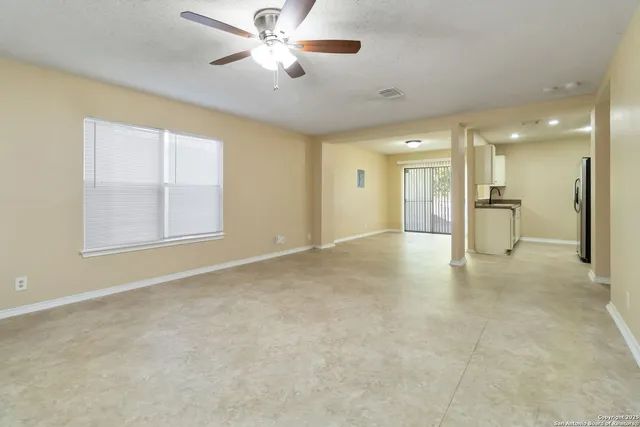 a view of empty room with a kitchen