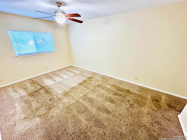 a view of empty room with a fan