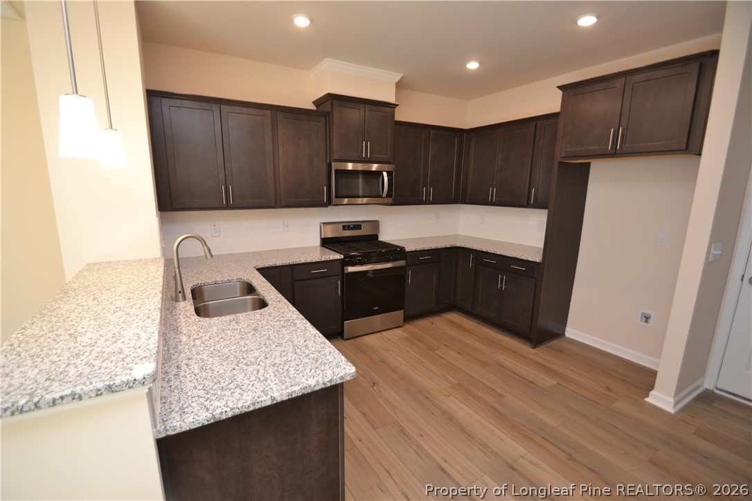 5703 Preveza Place Raleigh, NC 27603 - Photo 7 of 33 a kitchen with kitchen island sink refrigerator and cabinets