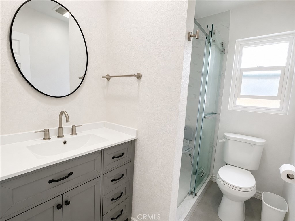 1118 West Orange Road Santa Ana, CA 92706 - Photo 9 of 18 a bathroom with a sink a mirror a toilet and a window