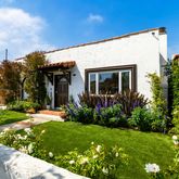 a front view of a house with a yard and potted plants