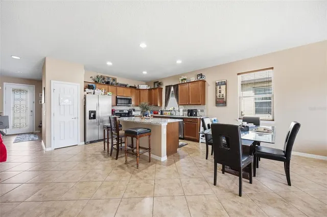 a open dining room kitchen with stainless steel appliances a dining table chairs and view living room