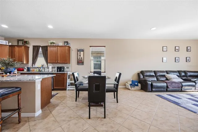 a living room with furniture a dining table and kitchen view