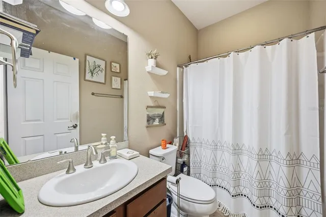 a bathroom with a sink a toilet and shower curtain