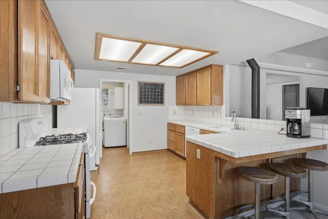 a kitchen with a sink a stove and chairs