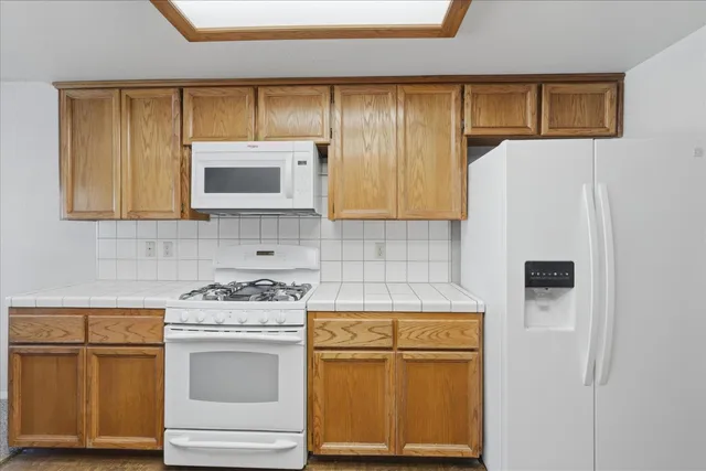 a kitchen with white cabinets and white appliances