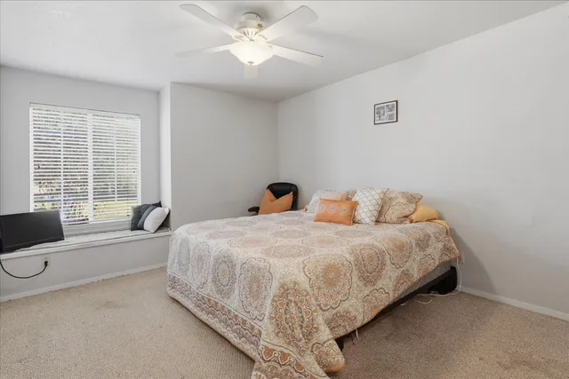 a bedroom with a bed and a large window