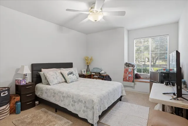 a bedroom with a bed a large window and flat screen tv