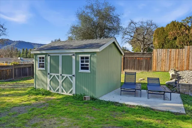 a view of a chairs and table in backyard of the house