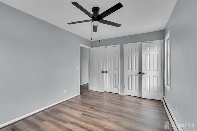 a view of room with hardwood floor and a ceiling fan
