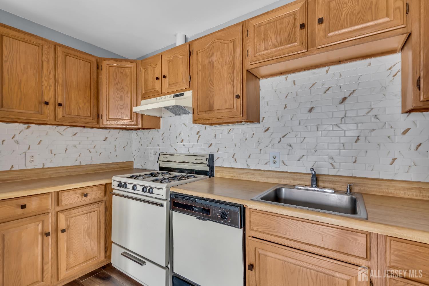 1595 East 2nd Street, Unit 2 Scotch Plains, NJ 07076 - Photo 2 of 13 a kitchen with stainless steel appliances granite countertop white cabinets and a stove top oven